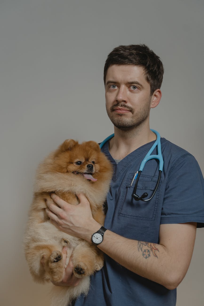 person with stethoscope around his neck holding a dog